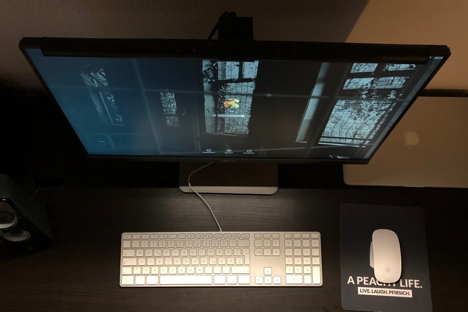 Aufgeräumter Schreibtisch: Monitor mit Screenbar und der beleuchtete Platz davor